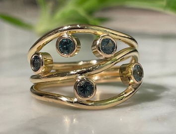 Ring in 18k gold with blue_green sapphires
