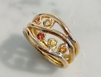 Ring in 18k gold with orange_yellow sapphires