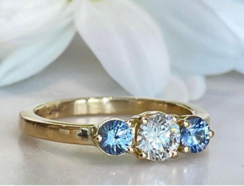 Ring in 18k yellow gold with a brilliant cut diamond and 2 light blue sapphires

